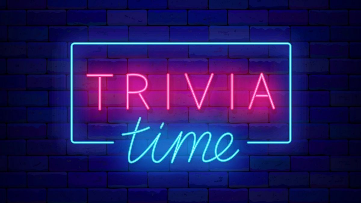 Neon sign with 'TRIVIA' in pink and 'time' in blue, against a brick wall.